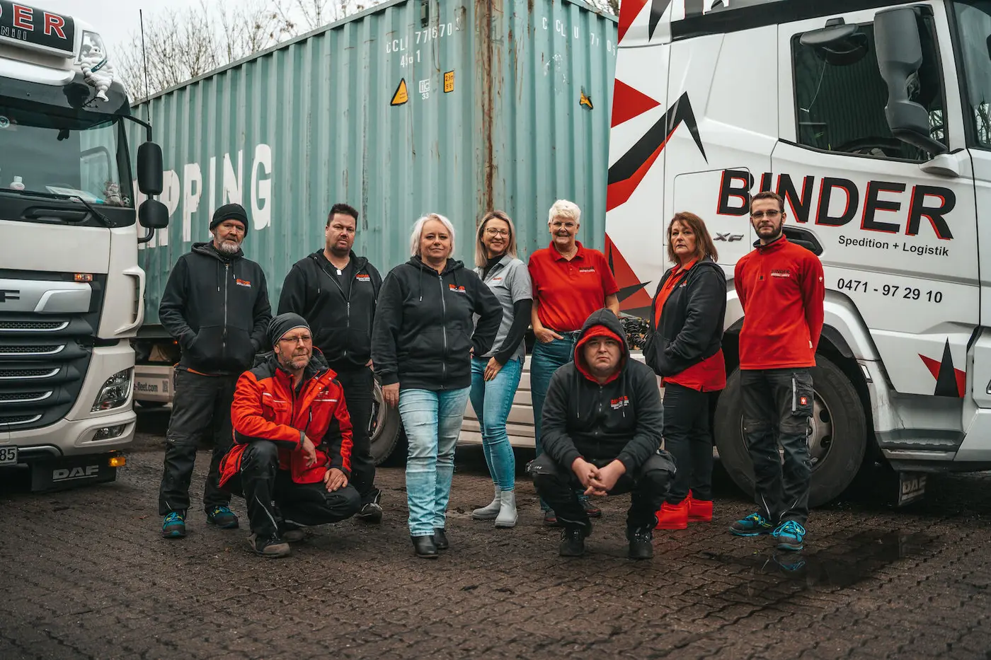 Das Team der Binder Spedition vor LKW und Container